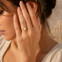 Gold plated adjustable ring with rectangular clear stone in beaded frame worn on hand